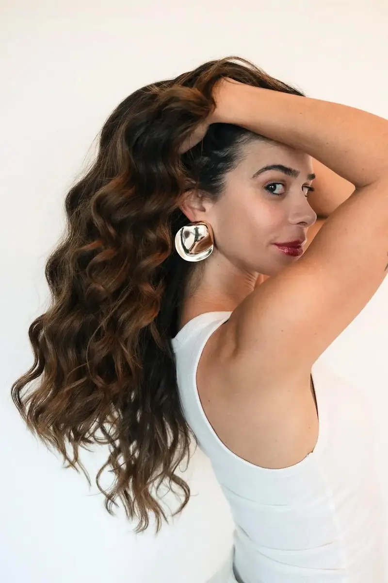 Priscilla Jorge de perfil, com o cabelo ondulado
