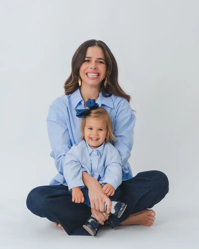 Priscilla Jorge com a filha no colo, as duas de camisa azul