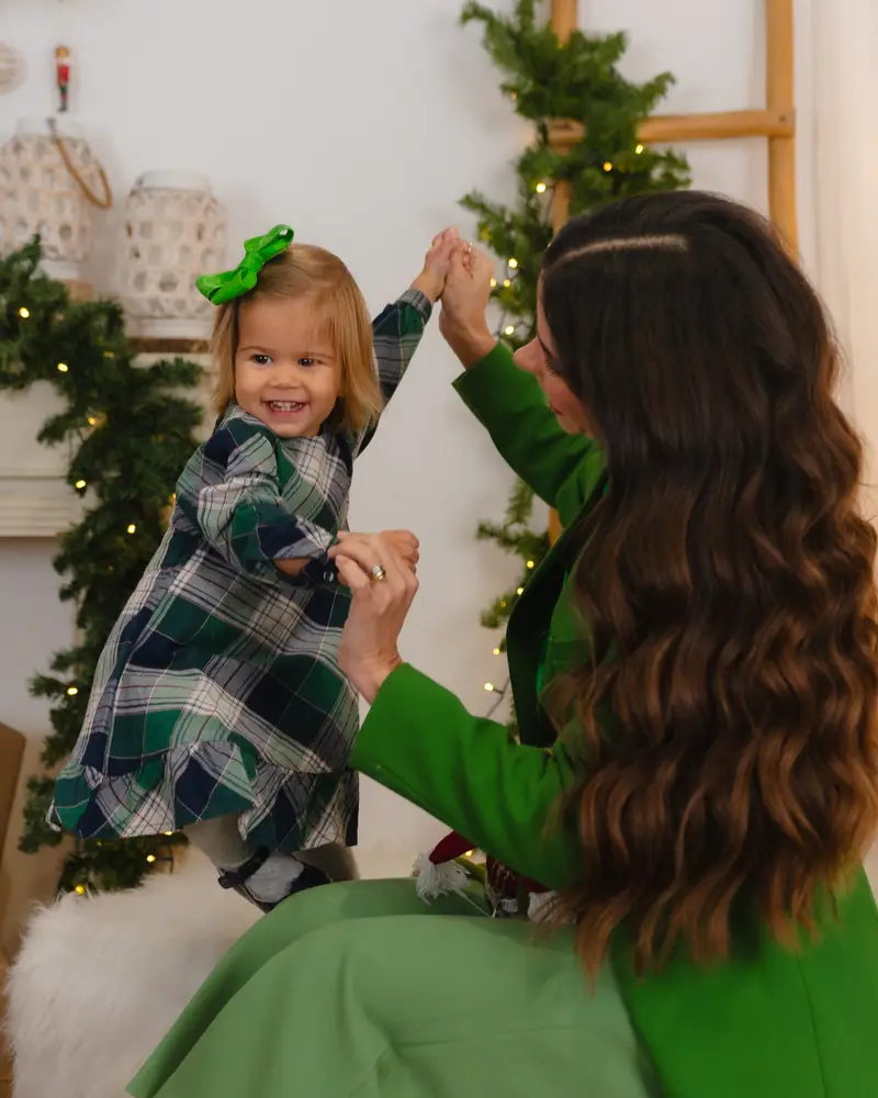 Priscilla Jorge brincando com a filha numa sala decorada para o Natal